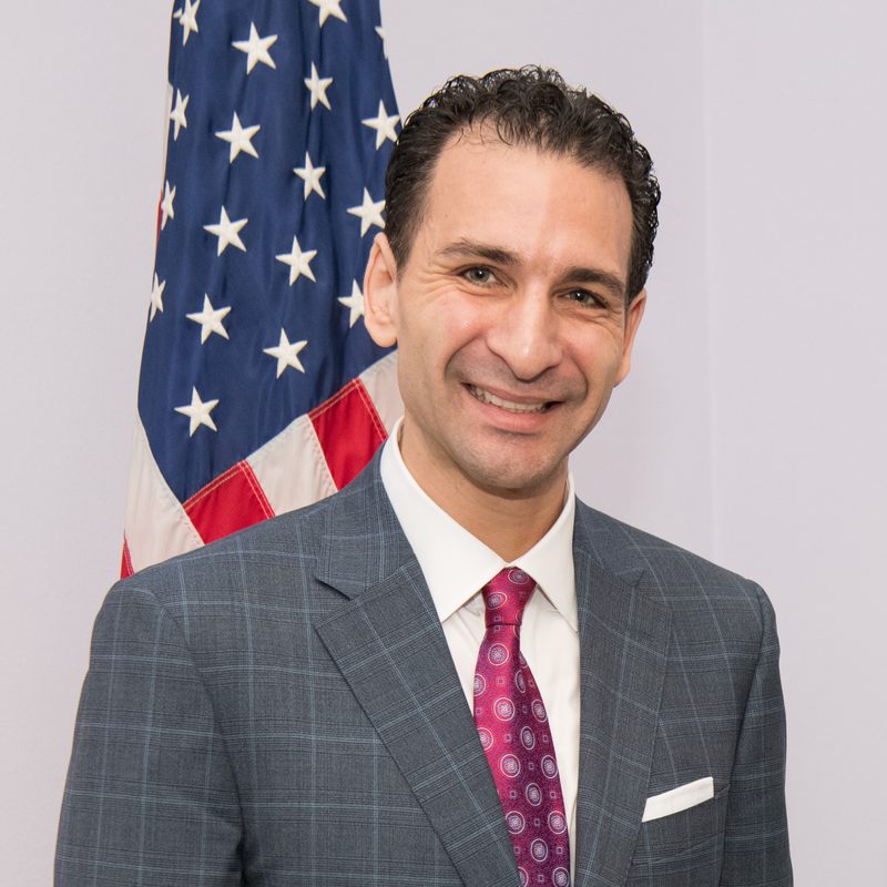 Petros Koumantaros in front of the American flag